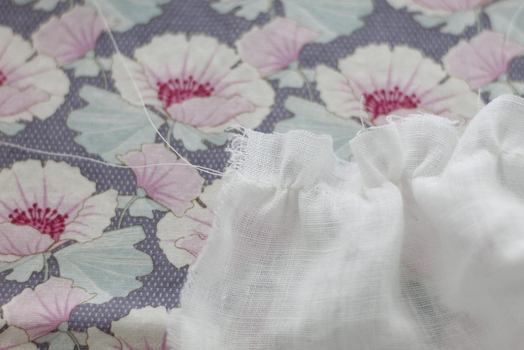 picture of gathered fabric with purple flowered background