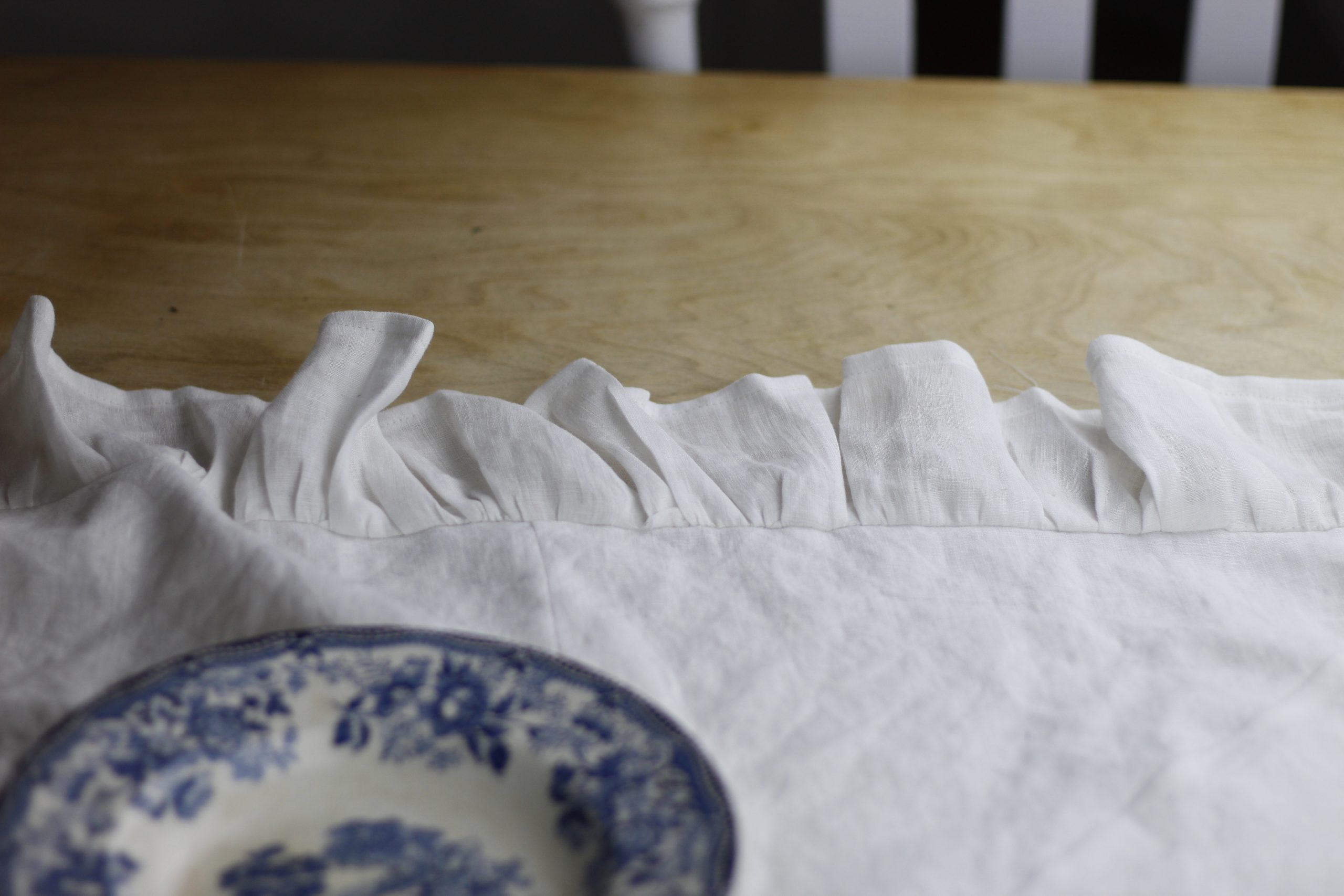 picture of finished sewn table runner on a table with a blue and white dish lying on it
