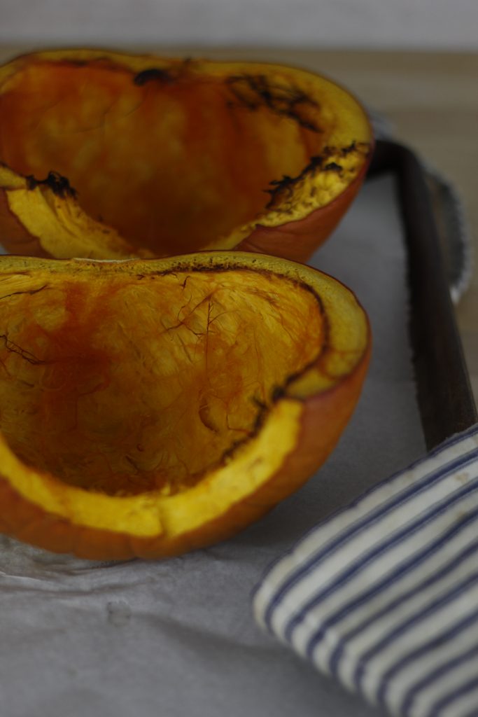 picture of roasted pumpkin half on baking sheet