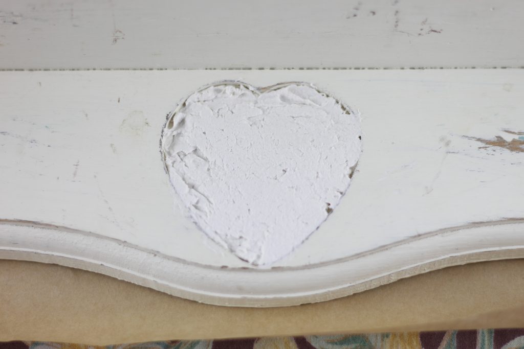 image of heart shaped hole in shelf filled in with paper mache clay