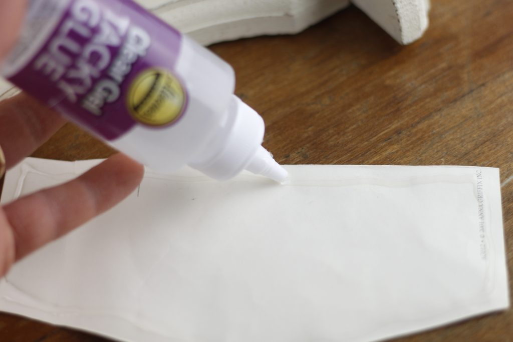 close up photo of glue being put onto back of paper
