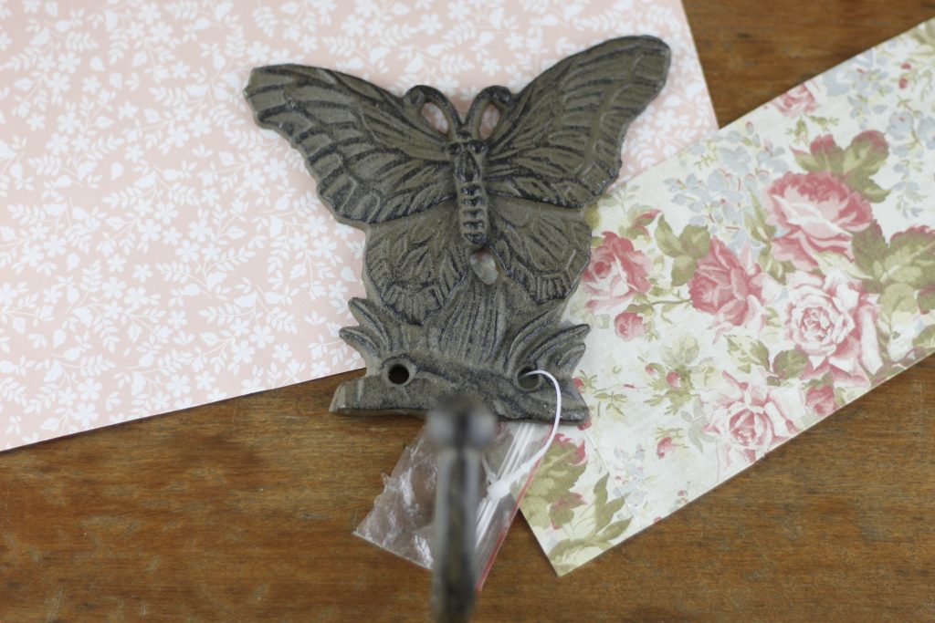 picture of paper and butterfly shaped metal hook on a table