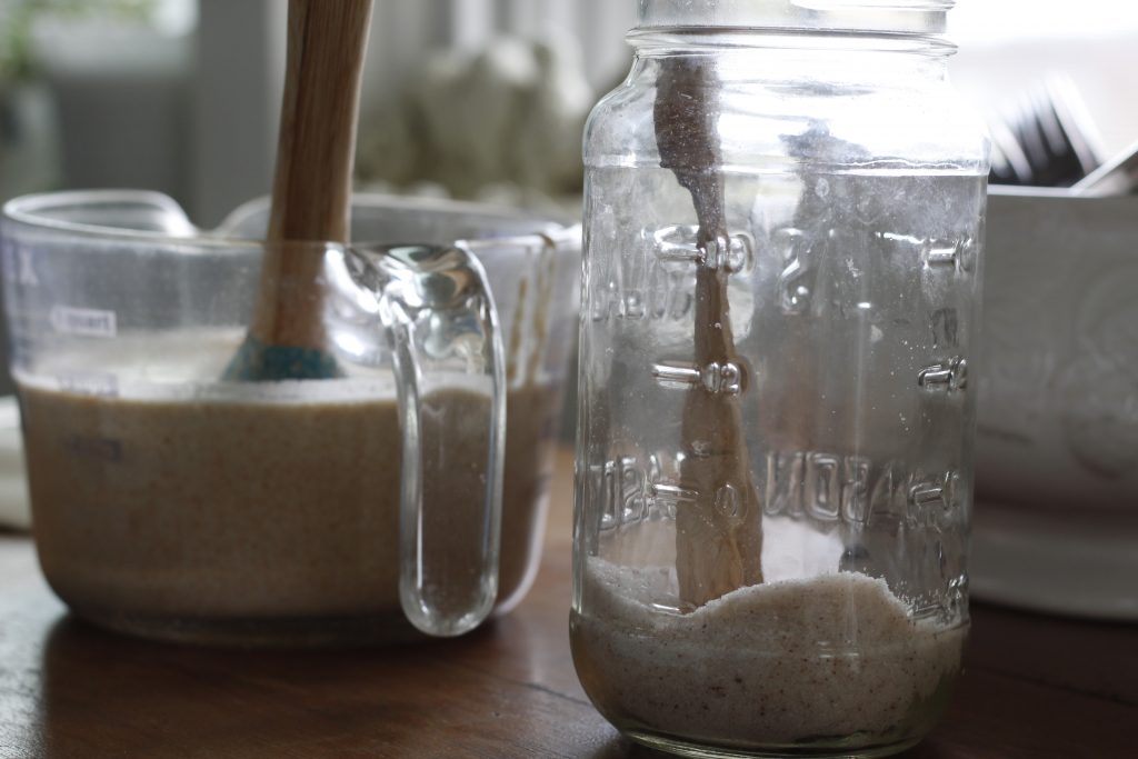 image of sourdough discard in a measuring bowl and a jar of salt on a table