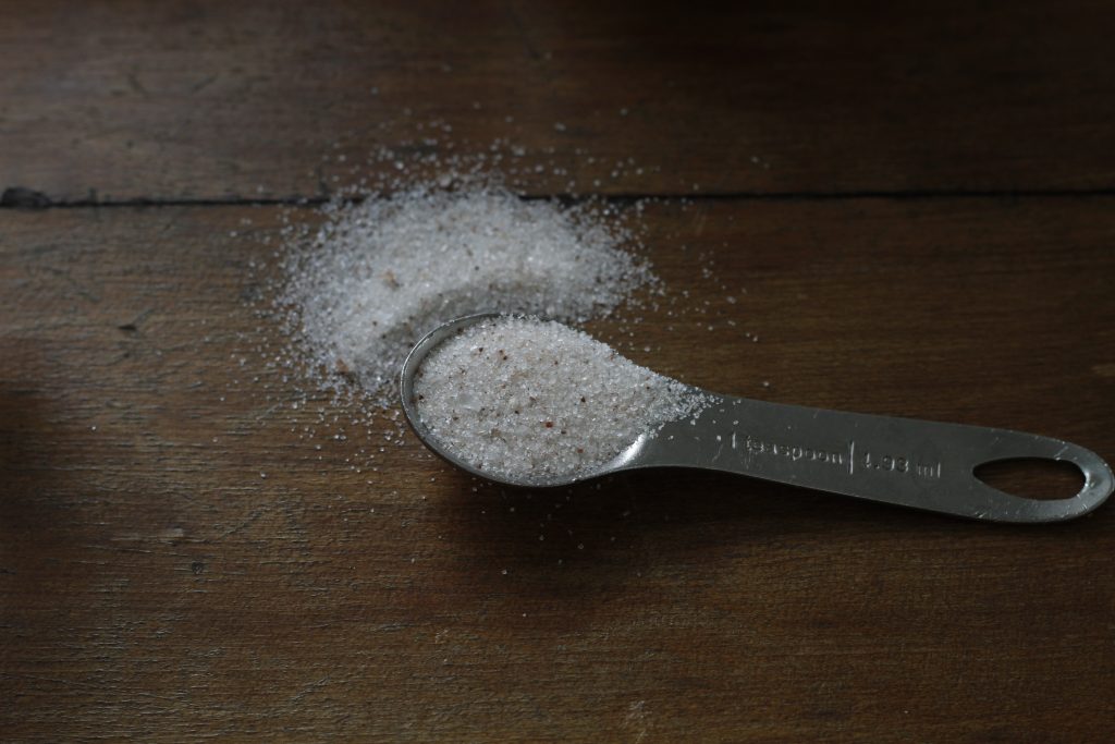 close-up image of one teaspoon salt placed on a table