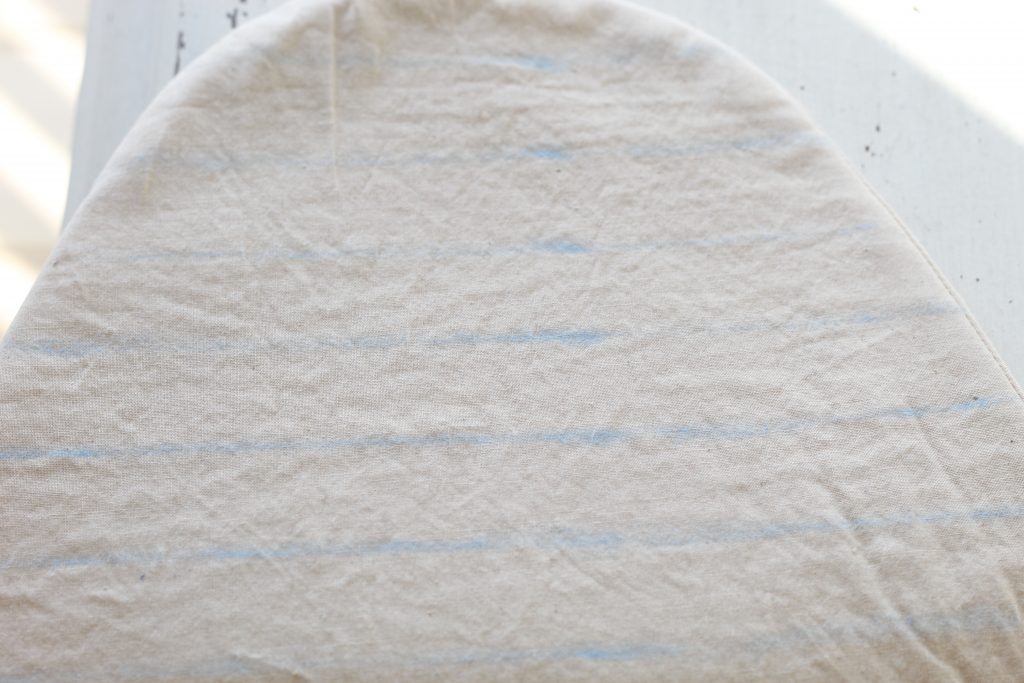 image of tan fabric lying on a white table with blue horizontal lines draw on it