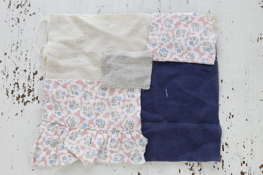 image of fabric scraps placed together to form a square to sew together lying on a white table