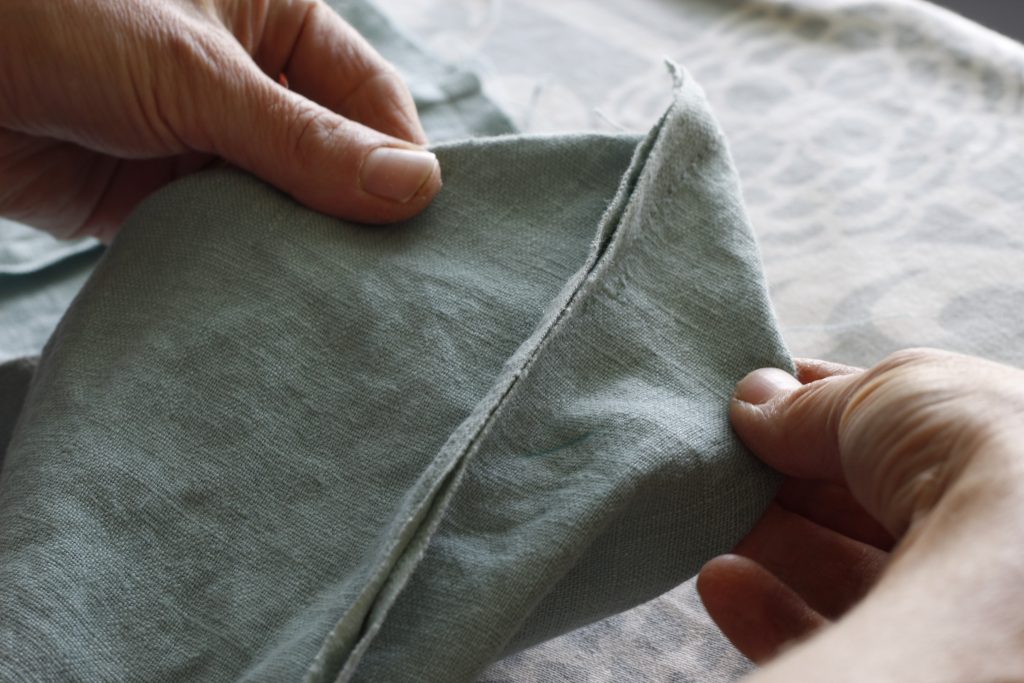 close-up picture of hands folding out a gusset on fabric