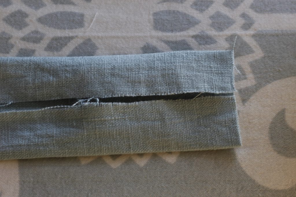 close-up picture of fabric folded twice lying on ironing board
