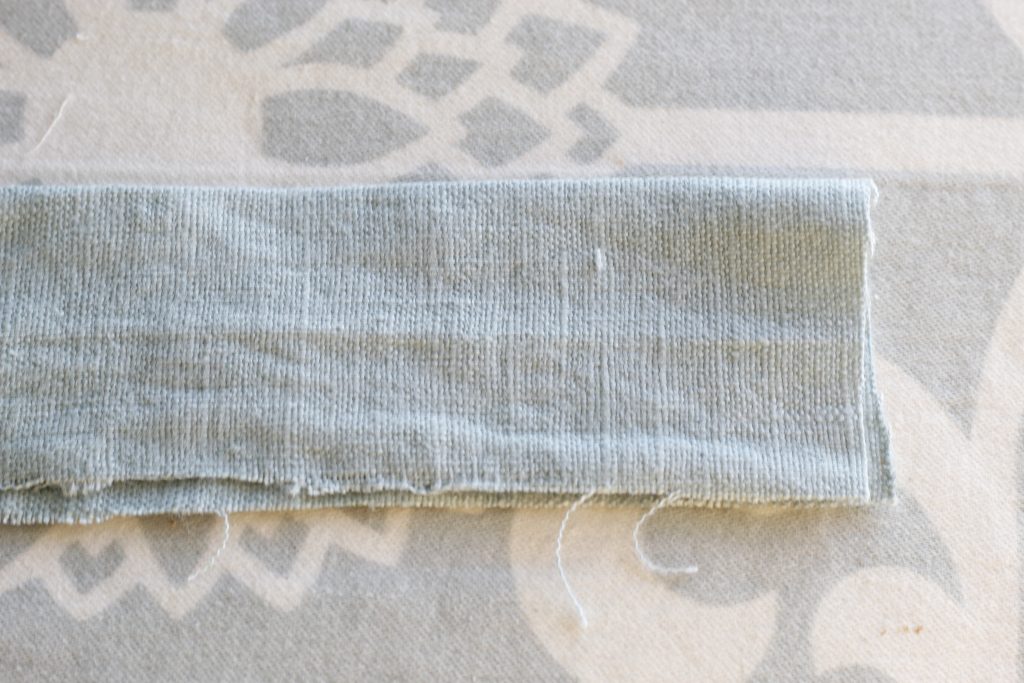 close-up picture of fabric folded in half lying on an ironing board