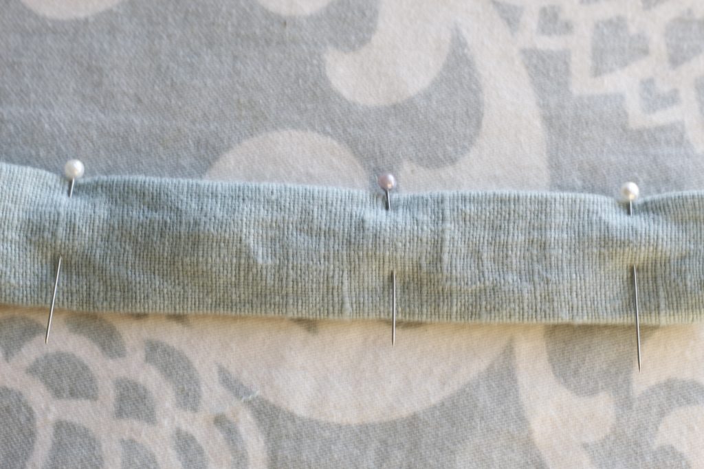 close-up picture of tote bag strap pinned lying on ironing board