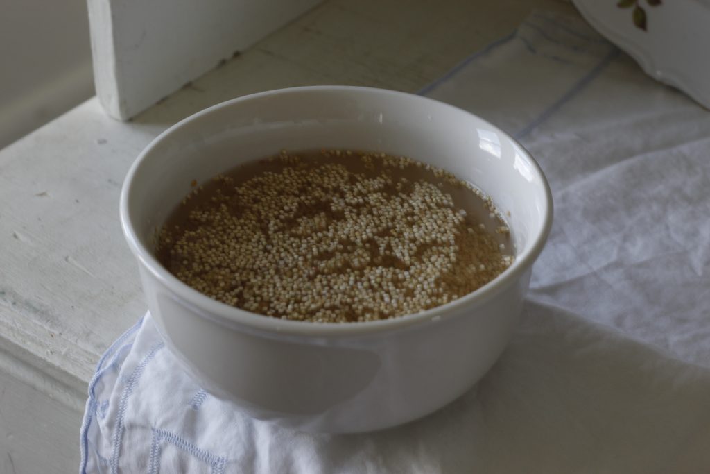 image of a white bowl on a tablecoth filled with quinoa and water