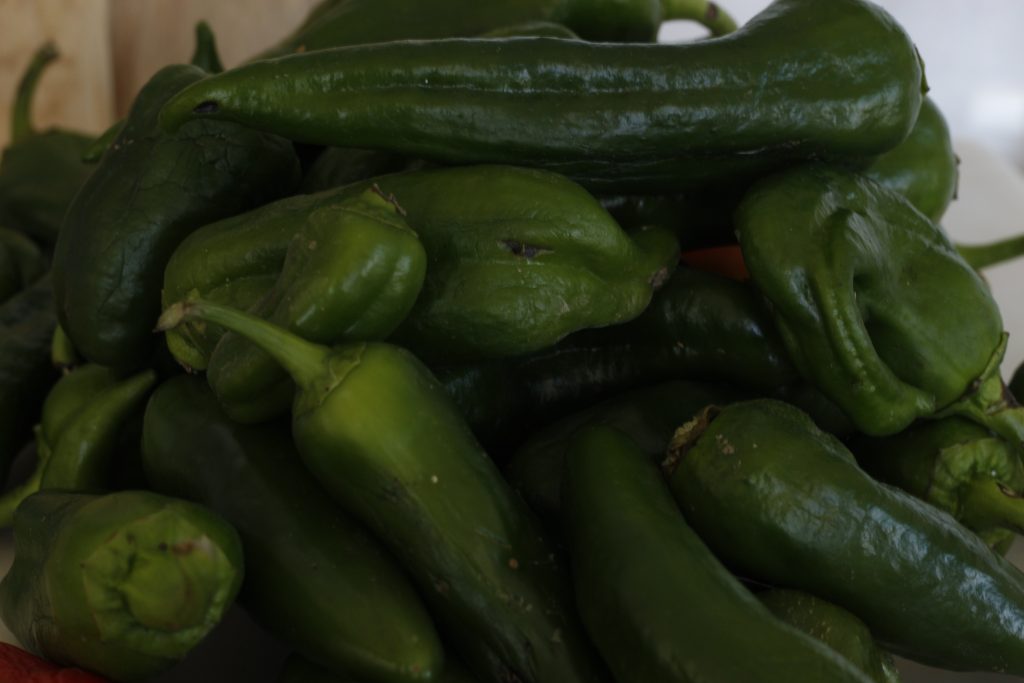 image of variety of green peppers piled on a countertop