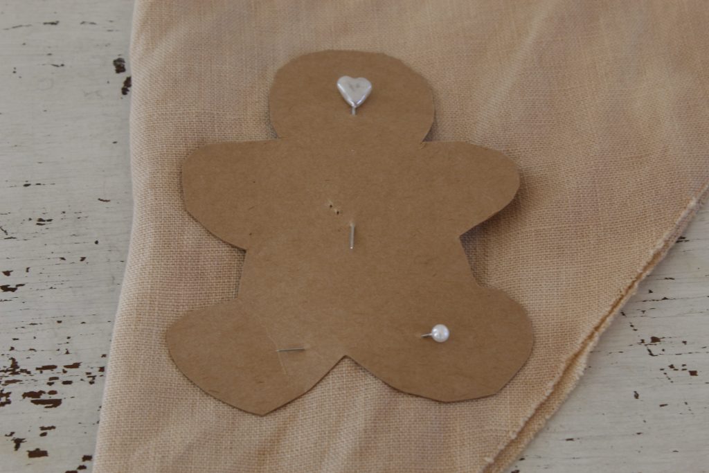 image showing gingerbread man sewing pattern pinned to linen fabric