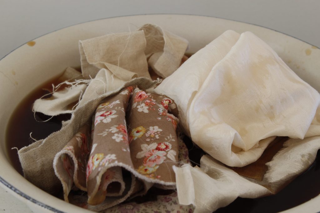 image of variety of fabric placed into white bowl of tea