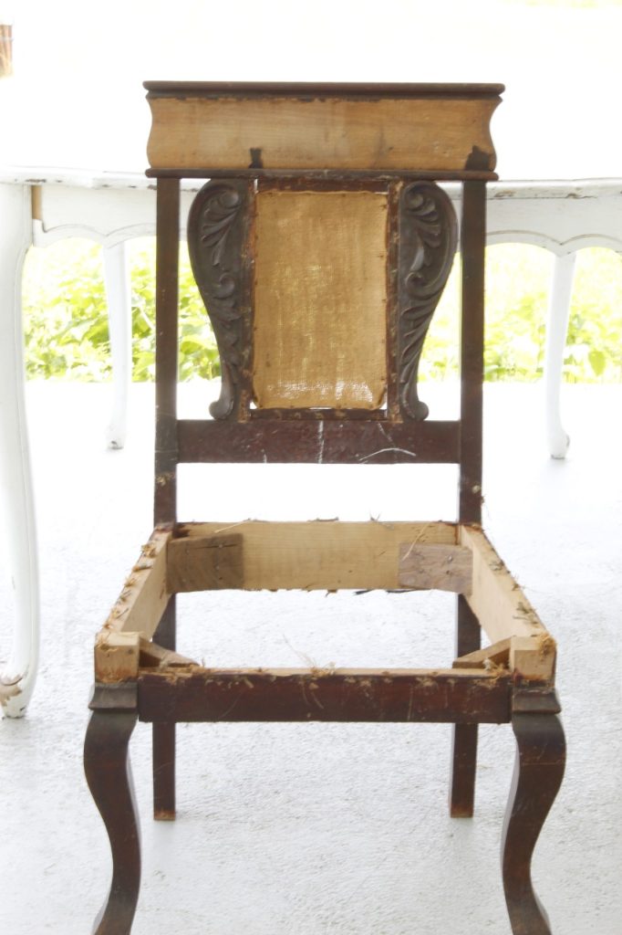 image of the chair stripped of fabric and the cushion and prepared to be refinished