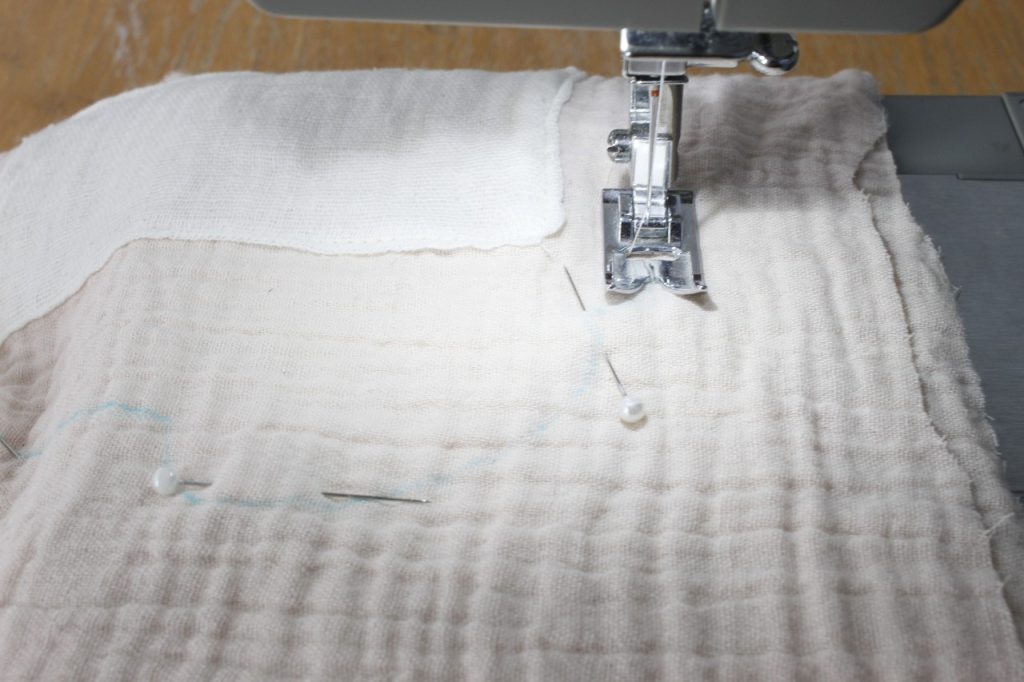 This is an image of a sewing machine sewing pink gauze fabric together.