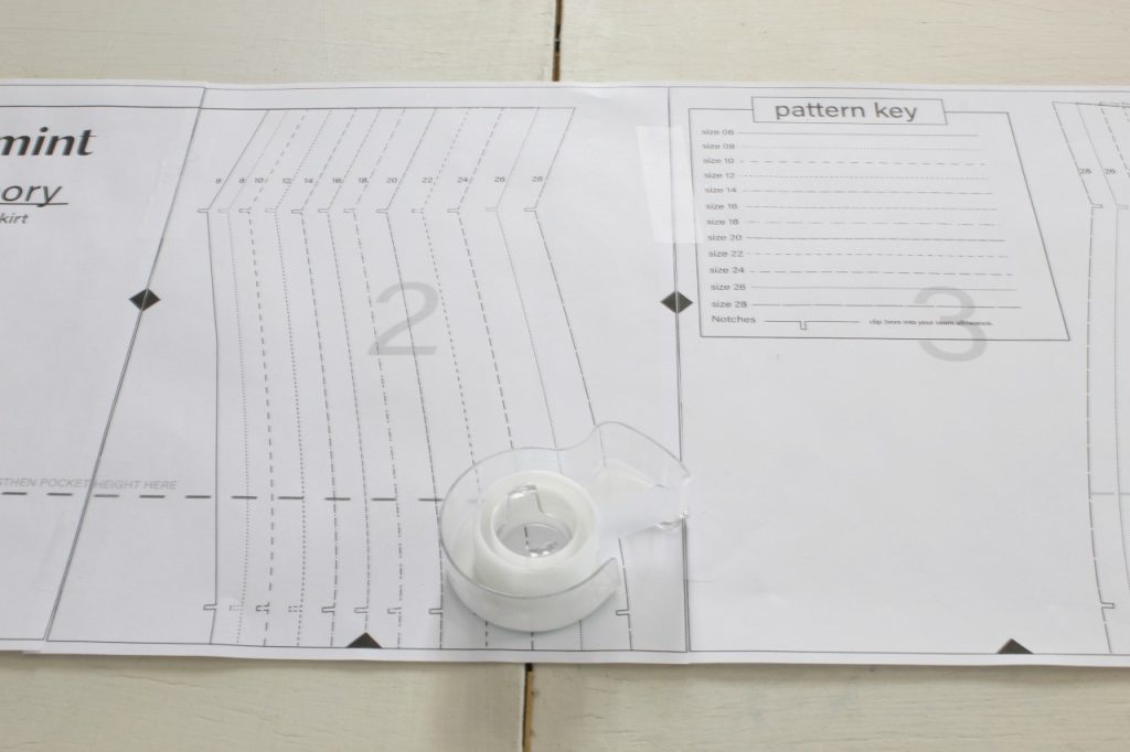 This image shows page 3 of the pattern taped to page 2 and there is a roll of clear tape lying on the pattern.