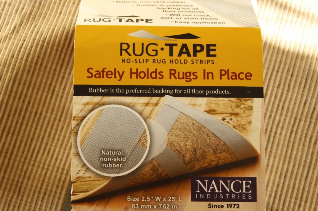 This image shows the rug tape that is being applied to the back of the handmade rug to keep it from slipping on the floor.