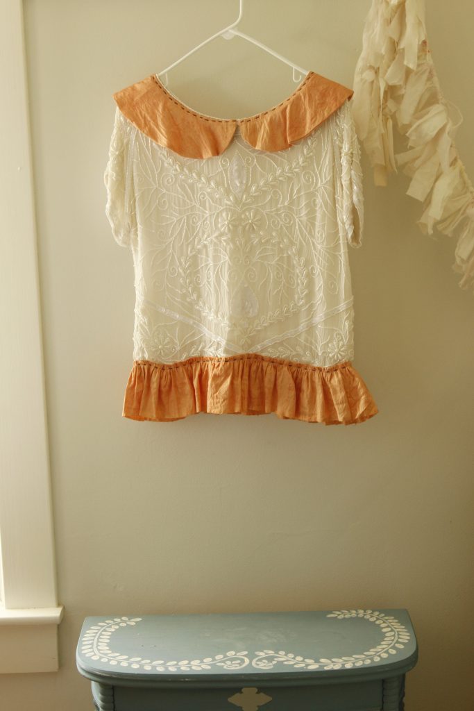 This image shows the naturally dyed silk fabric has been used on an up-cycle silk top project. The fabric was made into a bottom ruffle and a Peter Pan collar.