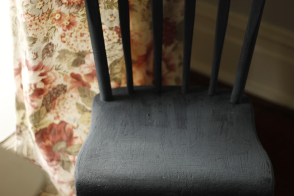 This is an image of the household chair by a floral curtain at a window, it has been painted with three coats of milk paint.