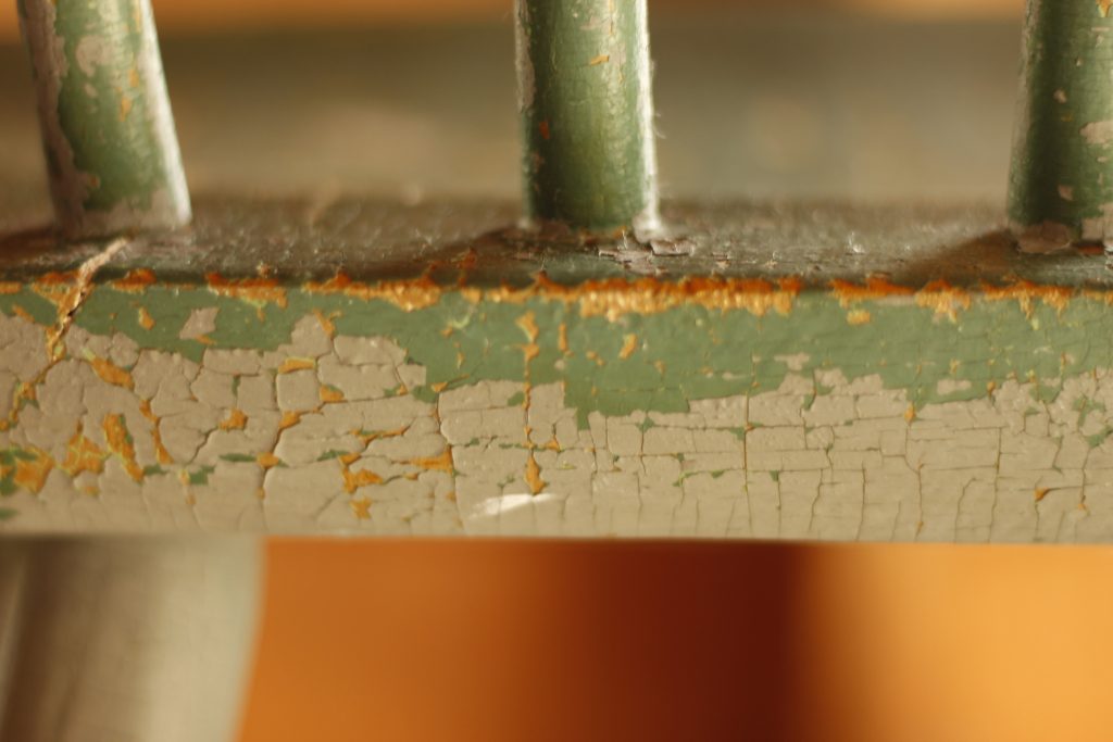 This image shows a close up view of the original paint job done with the gray paint that is chipping off.